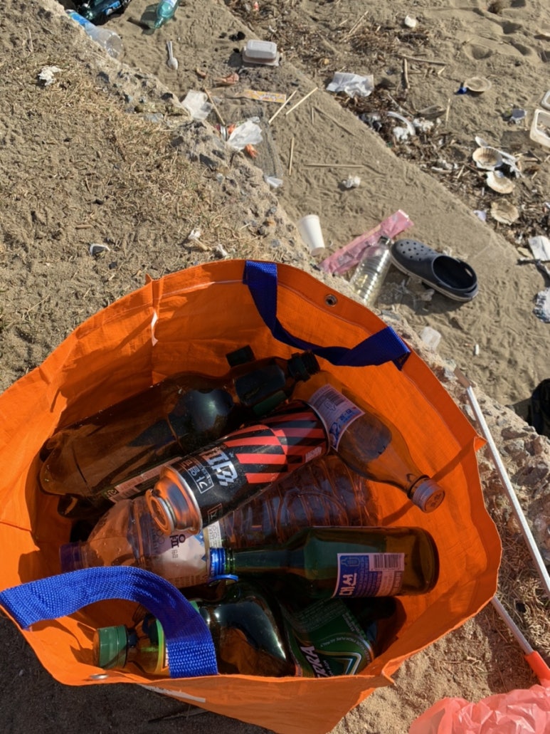 해변에서 소주병을 줍는 모습